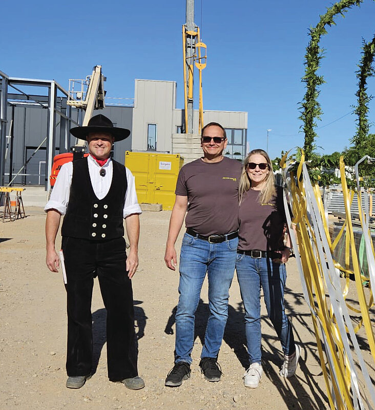 Drei Personen auf der Baustelle beim Richtfest