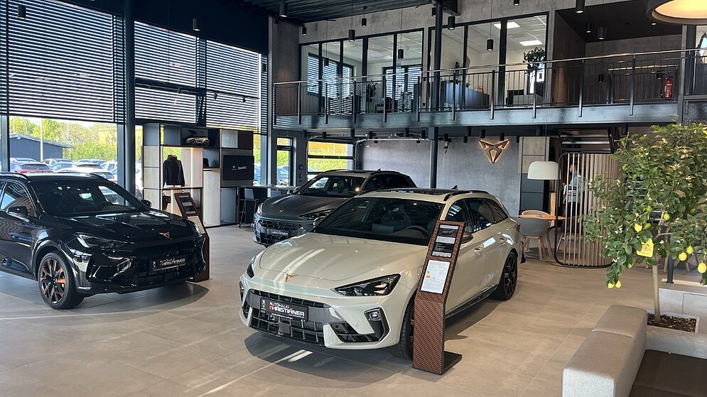 Lichtdurchflutete Ausstellungshalle mit Cupra Fahrzeugen und großen Glasfronten