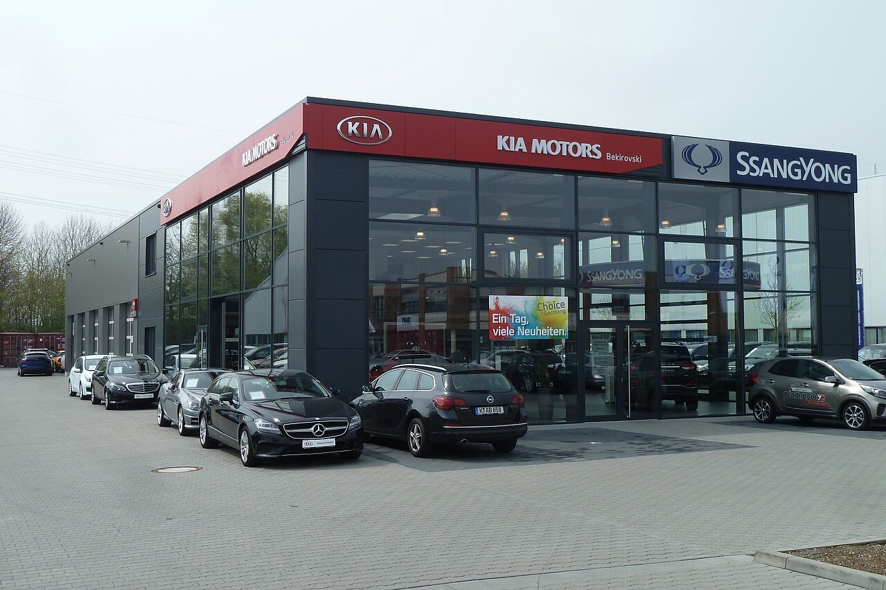 Schlüsselfertiges Autohaus für Kia und SsangYong mit moderner Glasfassade und Außenanlagen