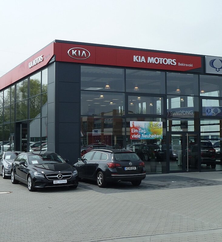 Schlüsselfertiges Autohaus für Kia und SsangYong mit moderner Glasfassade und Außenanlagen