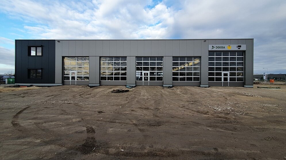 Werkstatteinfahrt mit großen Toren und unbefestigter Außenanlage