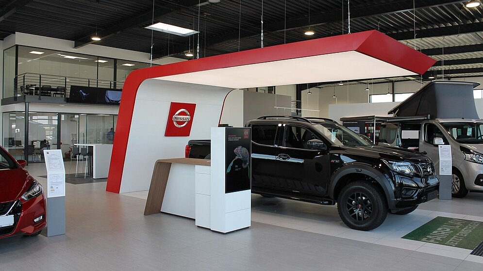 Präsentationsfläche im Autohaus mit Nissan-Branding und Pickup-Ausstellung