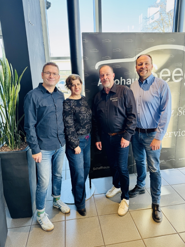 vier Personen in einem Autohaus