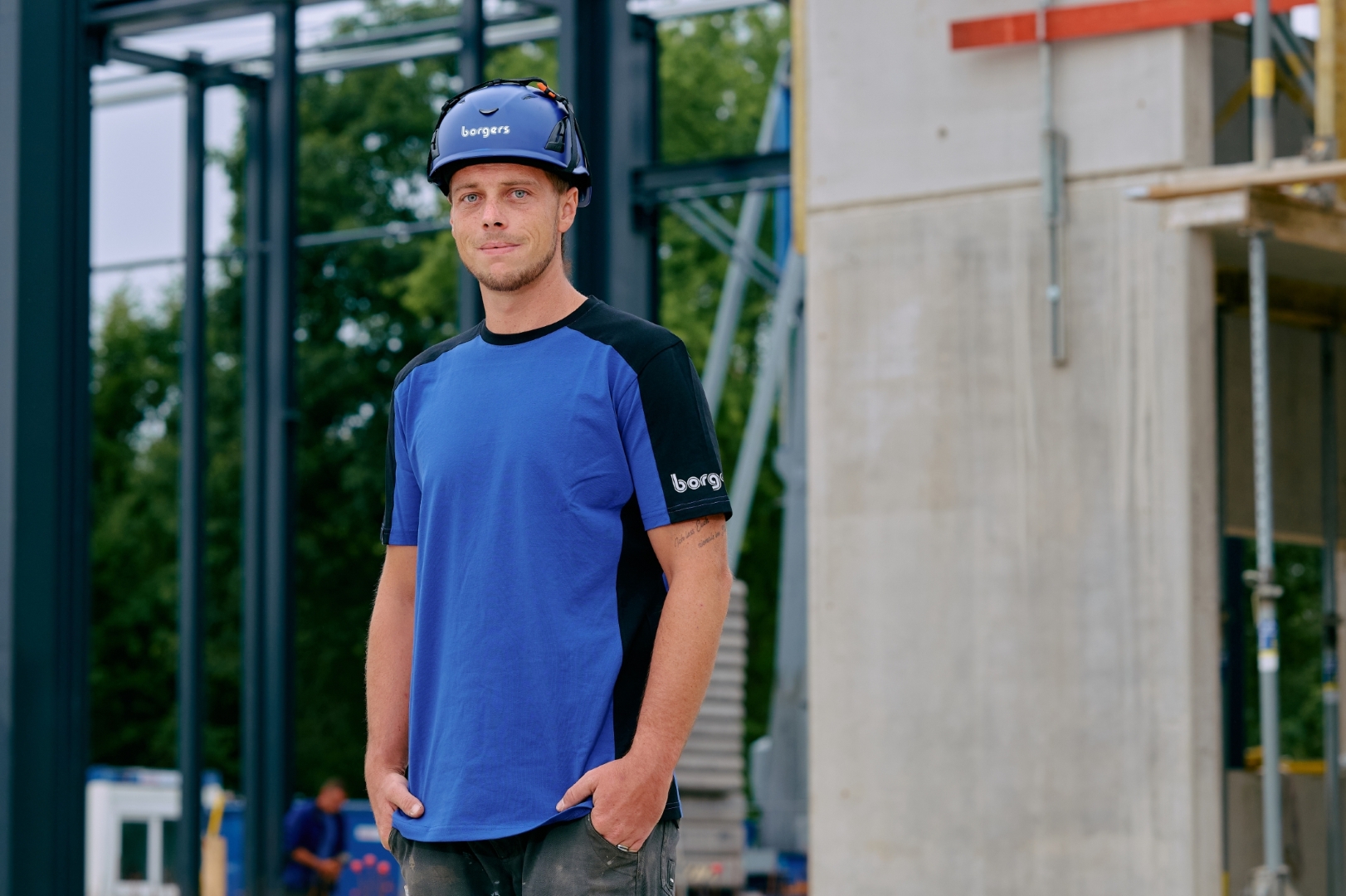 ein Borgers Kollege auf der Baustelle mit Borgers Helm und blauem Shirt