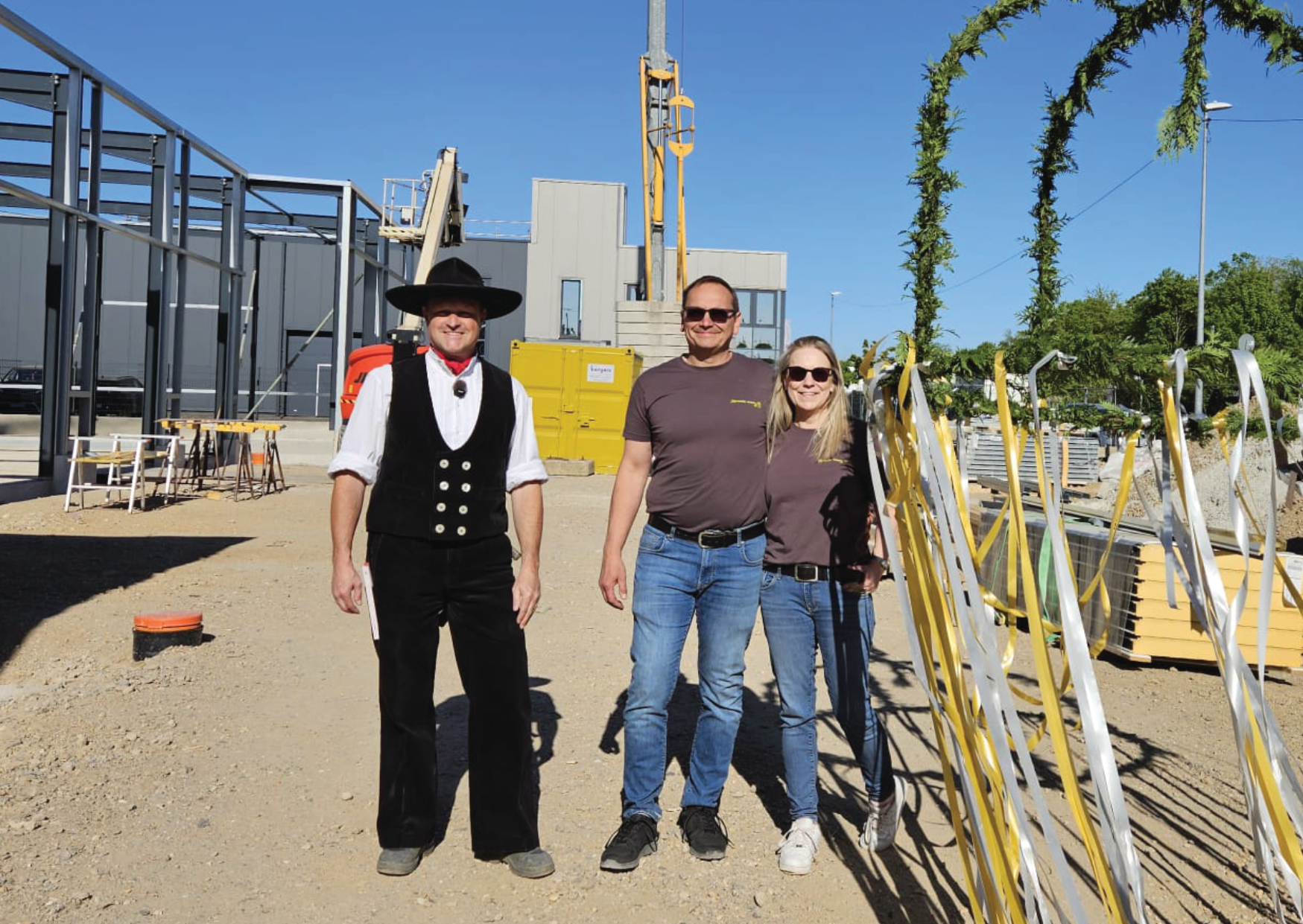 Drei Personen auf der Baustelle beim Richtfest